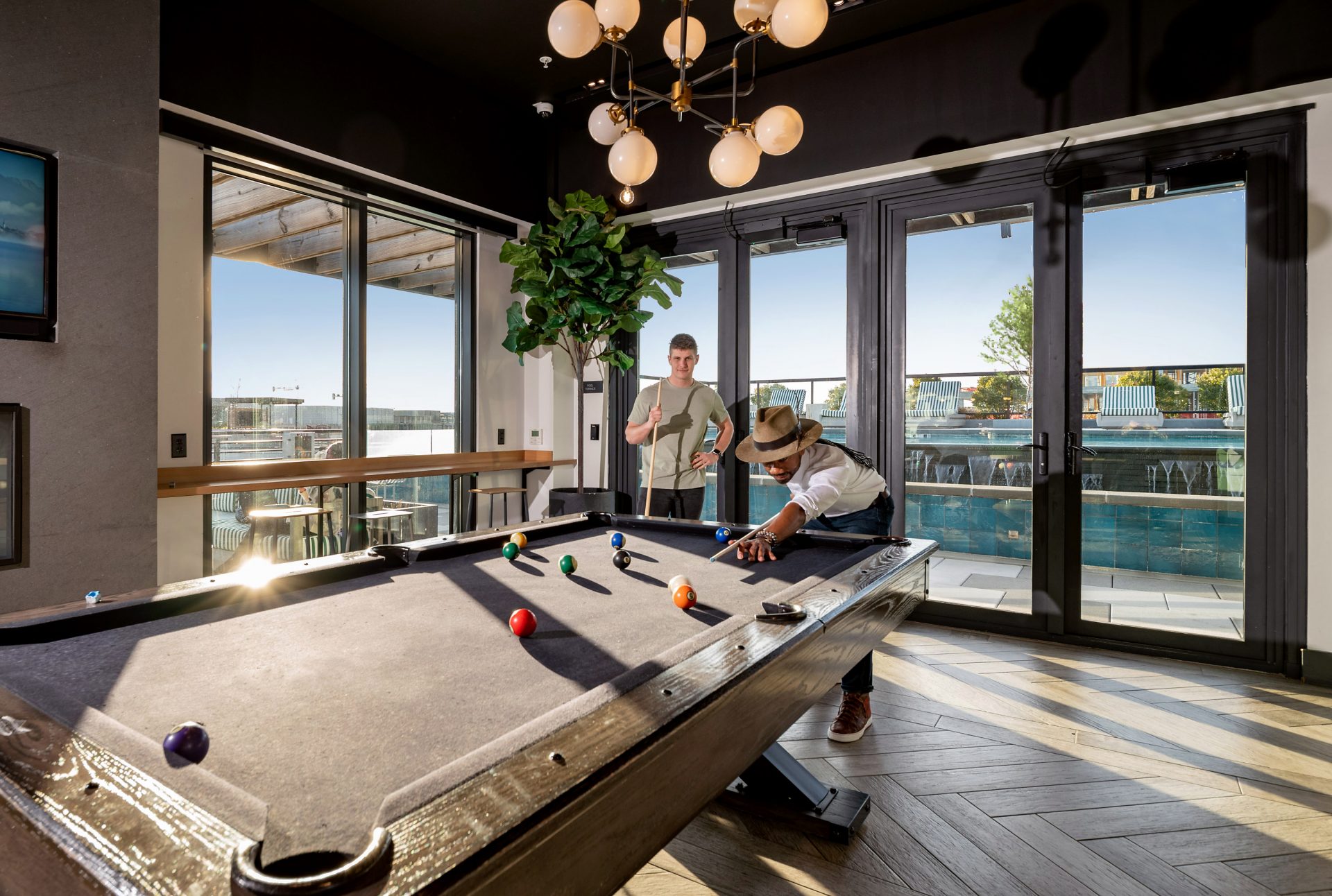 billiards table next to fireplace and television